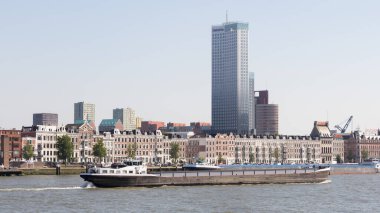 Rotterdam, Hollanda - 21 Haziran 2018: Gökyüzü çöplüğü, evler ve şehirden geçen bir yük gemisi ile Rotterdam şehri