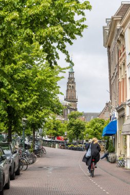 Leiden, Hollanda - 25 Mayıs 2025: Hollanda 'nın güneyinde Nieuwe Rijn Kanalı' nda bisiklet süren Leiden şehir merkezi öğrencisi