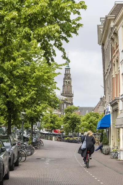 Leiden, Hollanda - 25 Mayıs 2025: Hollanda 'nın güneyinde Nieuwe Rijn Kanalı' nda bisiklet süren Leiden şehir merkezi öğrencisi