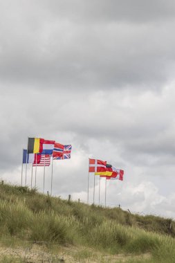 1944 yazında Utah sahiline düzenlenen çıkartma günü saldırısına katılan ülkelerin rüzgarlarında dalgalanan bayraklar.