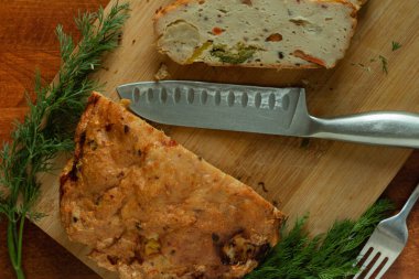 Taze et turtasının üst görüntüsü. Bambu dalları, çatal ve bıçakla kesme tahtası ve biraz da ahşap arka plan.