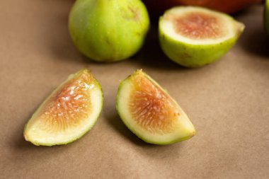 Açık kahverengi arka planda ikiye bölünmüş incir parçaları.