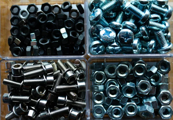 photo - close-up top view - steel nuts black and steel - and screws for hex and cross wrench - in boxes