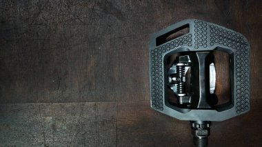 Siyah plastik Düz Pedal SPD Cleat Sistemi ile koyu tahta arka plan görünümü