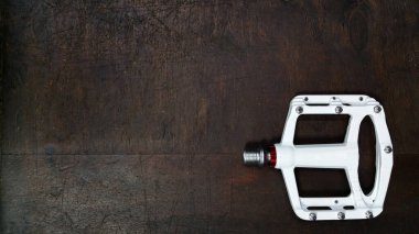Beyaz alüminyum ince düz pedal, koyu ahşap arka plan görünümlü, değiştirilebilir çiviler.