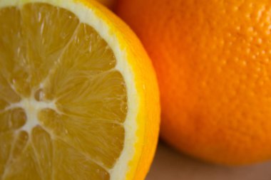 Açık kahverengi arkaplanda turuncuyla yarım portakal yakın plan.