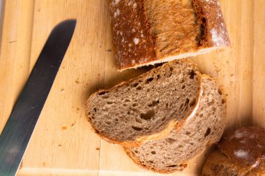 photograph of sliced whole grain bread on a wooden cutting board - top view