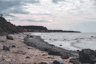 Kum kayaları ve küçük dalgalarla Baltık kıyı şeridi manzarası. Fotoğraf Letonya 'da çekildi, Jurkalne. Bulutlu bir gün.