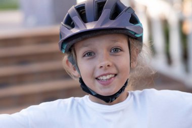 Child helmet for rollers, Pretty little girl learning to roller skate outdoors, Happy girl, Have a free time, summer and outdoors. High quality photo