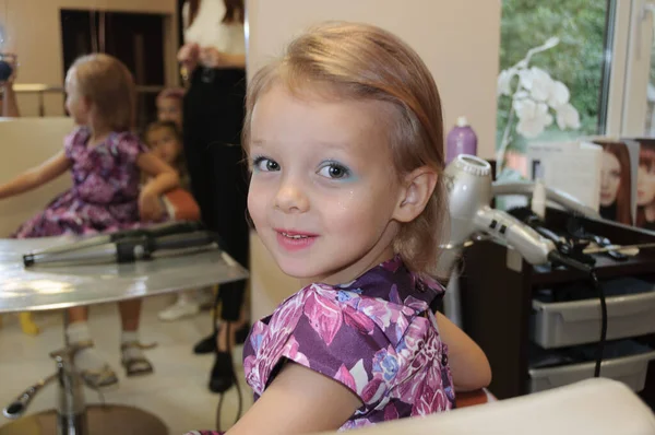 The girl had her hair done and her face painted. Baby makeup. High quality photo