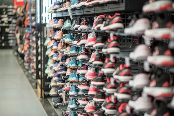 stock image Shop display of a lot of Sports shoes on a wall. A view of a wall of shoes inside the store. Modern new stylish sneakers running shoes for men and women - Dubai UAE December 2019. High quality photo