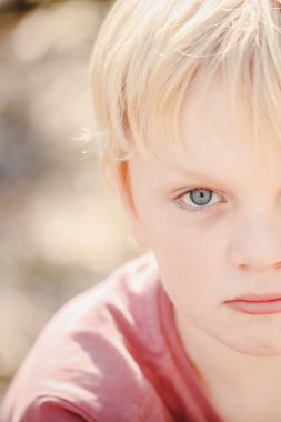 Close up portrait image of young boy with serious expression