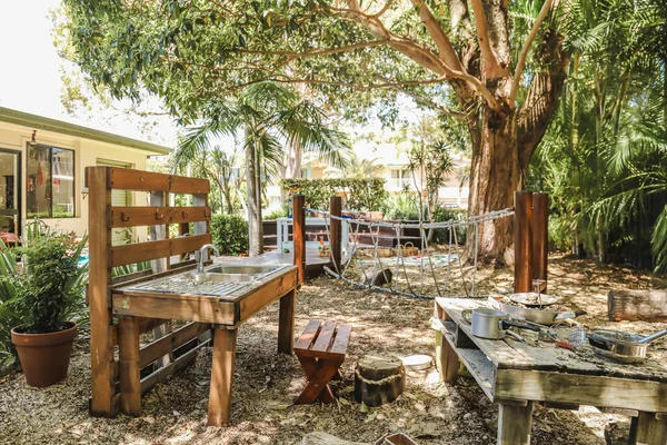 Mud kitchen in tropical preschool garden. Kindergarten yard in Australia.