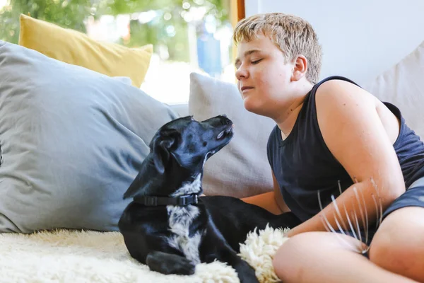 Мальчик Подросток Обнимается Диване Собакой Лучший Друг Человека Чёрная Порода — стоковое фото