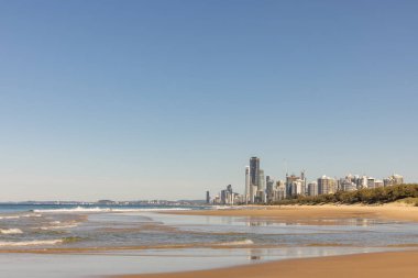 Gold Coast 'taki Main Beach' in altın kumu, Sörfçülerin Cennet Turizmi 'nin varış noktası olan şehrin ufuk çizgisi. Sahilin aşağısındaki Southport 'tan görüntü