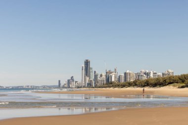Gold Coast 'taki Main Beach' in altın kumu, Sörfçülerin Cennet Turizmi 'nin varış noktası olan şehrin ufuk çizgisi. Sahilin aşağısındaki Southport 'tan görüntü