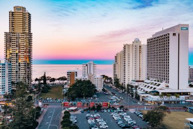 Sörfçüler Paradise QLD Avustralya - 9 Temmuz 2023: Yüksek binalar, apartmanlar ve günbatımında canlı renkli gökyüzü ile Gold Coast şehir siluetini oluşturan lüks oteller