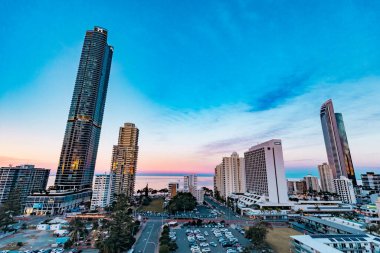 Sörfçüler Paradise QLD Avustralya - 9 Temmuz 2023: Yüksek binalar, apartmanlar ve günbatımında canlı renkli gökyüzü ile Gold Coast şehir siluetini oluşturan lüks oteller