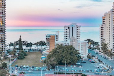 Sörfçüler Paradise QLD Avustralya - 9 Temmuz 2023: Yüksek binalar, apartmanlar ve günbatımında pembe ve mor gökyüzü ile Gold Coast 'a bakan lüks oteller