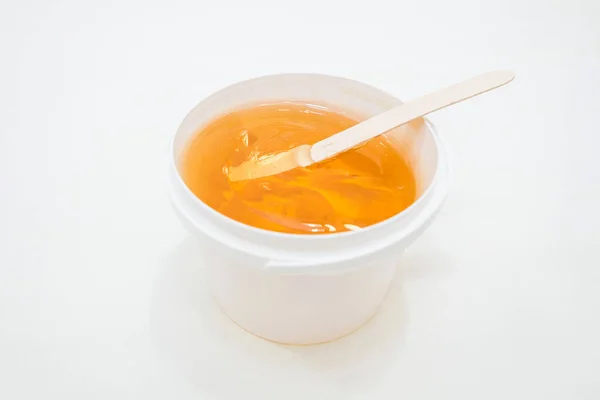 Plastic bucket with sugaring paste on white background.Shugaring concept.