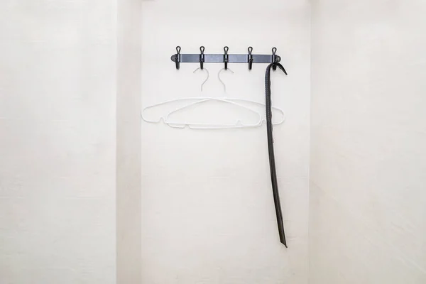 hanger on a white wall. Hooks for outerwear.