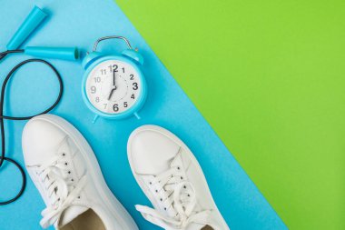Spor konsepti, fitness. İki ton yeşil ve mavi arkaplanlı ve kopyalanmış halat alarmlı beyaz rozetlerin fotoğrafı. Spor, egzersiz zamanı.