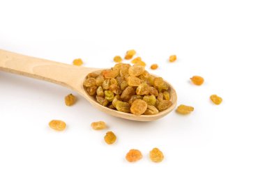 Beyaz arka planda izole edilmiş kaşıkta kuru üzümler.