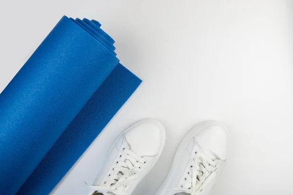 Φωτογραφία Από Μπλε Fitness Mat Και Λευκά Sneakers Λευκό Φόντο — Φωτογραφία Αρχείου