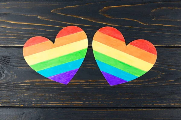 LGBT symbol, two rainbow hearts on a wooden background, rights and gender equality.