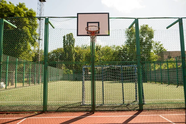 Red basketball hoop with net with green leaves background. Sport concept