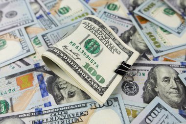 Masanın üzerinde büyük miktarlarda yüz dolar yatıyor. Çok para. Mali konsept.
