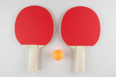 Spor kompozisyonu. Masa tenisi yakın çekim. Beyaz arkaplanda oynamak için raketler ve top