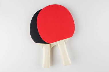 Spor kompozisyonu. Masa tenisi yakın çekim. Beyaz arkaplanda oynamak için raketler ve top