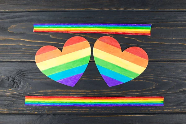 LGBT symbol, two rainbow hearts on a wooden background, rights and gender equality.