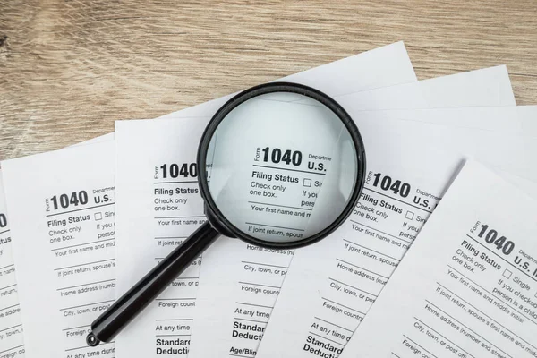 blank of individual tax form with magnifying glasses, tax and income concept