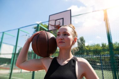 Basketbol sahasında basketbol oynayan genç bir kız, aktif bir hafta sonu..