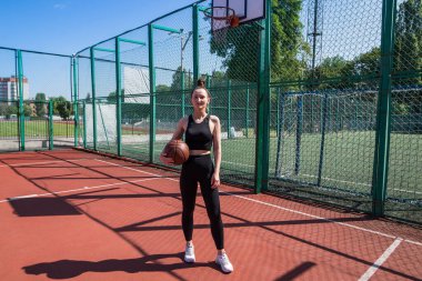 Basketbol sahasında basketbol oynayan genç bir kız, aktif bir hafta sonu..