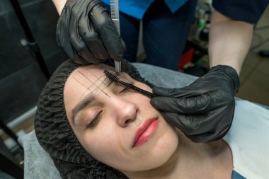 Makyöz güzellik salonunda kaş yoluyor. Profesyonel makyaj ve kozmetoloji cilt bakımı.