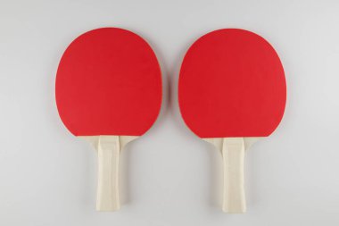 Spor kompozisyonu. Masa tenisi yakın çekim. Beyaz arkaplanda oynamak için raketler ve top