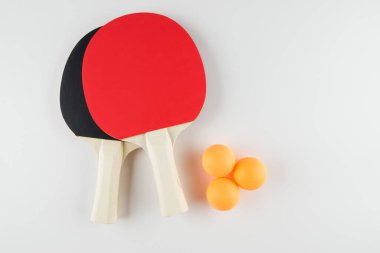 Spor kompozisyonu. Masa tenisi yakın çekim. Beyaz arkaplanda oynamak için raketler ve top