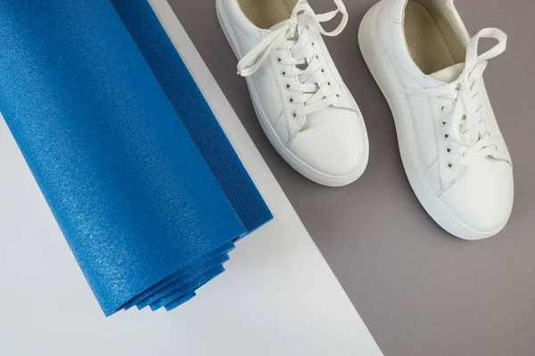 stock image Top view photo of white sneakers and fitness mat. The concept of sport, yoga, fitness.