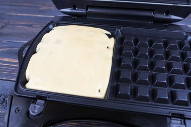 Belçika waffle 'ı yapma süreci. Waffle hamurunu waffle makinesine dök.