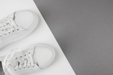 Siyah beyaz arka plandaki beyaz spor ayakkabılarının fotokopi alanı ile en üstteki görünümü.