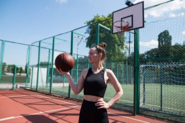 Basketbol sahasında basketbol oynayan genç bir kız, aktif bir hafta sonu..