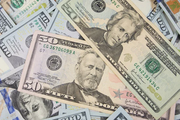 Masanın üzerinde büyük miktarlarda yüz dolar yatıyor. Çok para. Mali konsept.