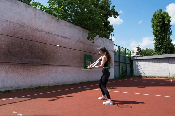 Genç tenisçi kız duvarda oynuyor. Profesyonel spor..