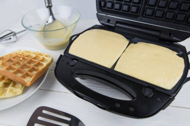 Evdeki waffle ızgarasında Belçika Waffle 'ı yapma sürecine yakın çekim. Waffle ızgarasında Belçika waffle 'ı.