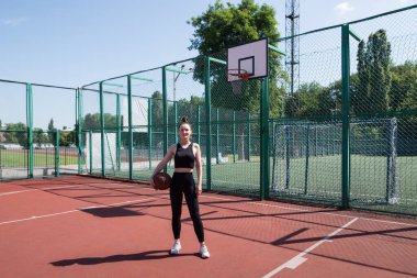Basketbol sahasında basketbol oynayan genç bir kız, aktif bir hafta sonu..