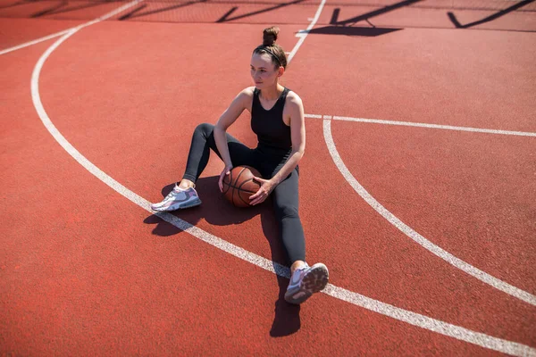 Basketbol sahasında basketbol oynayan genç bir kız, aktif bir hafta sonu..