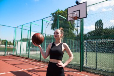 Basketbol sahasında basketbol oynayan genç bir kız, aktif bir hafta sonu..